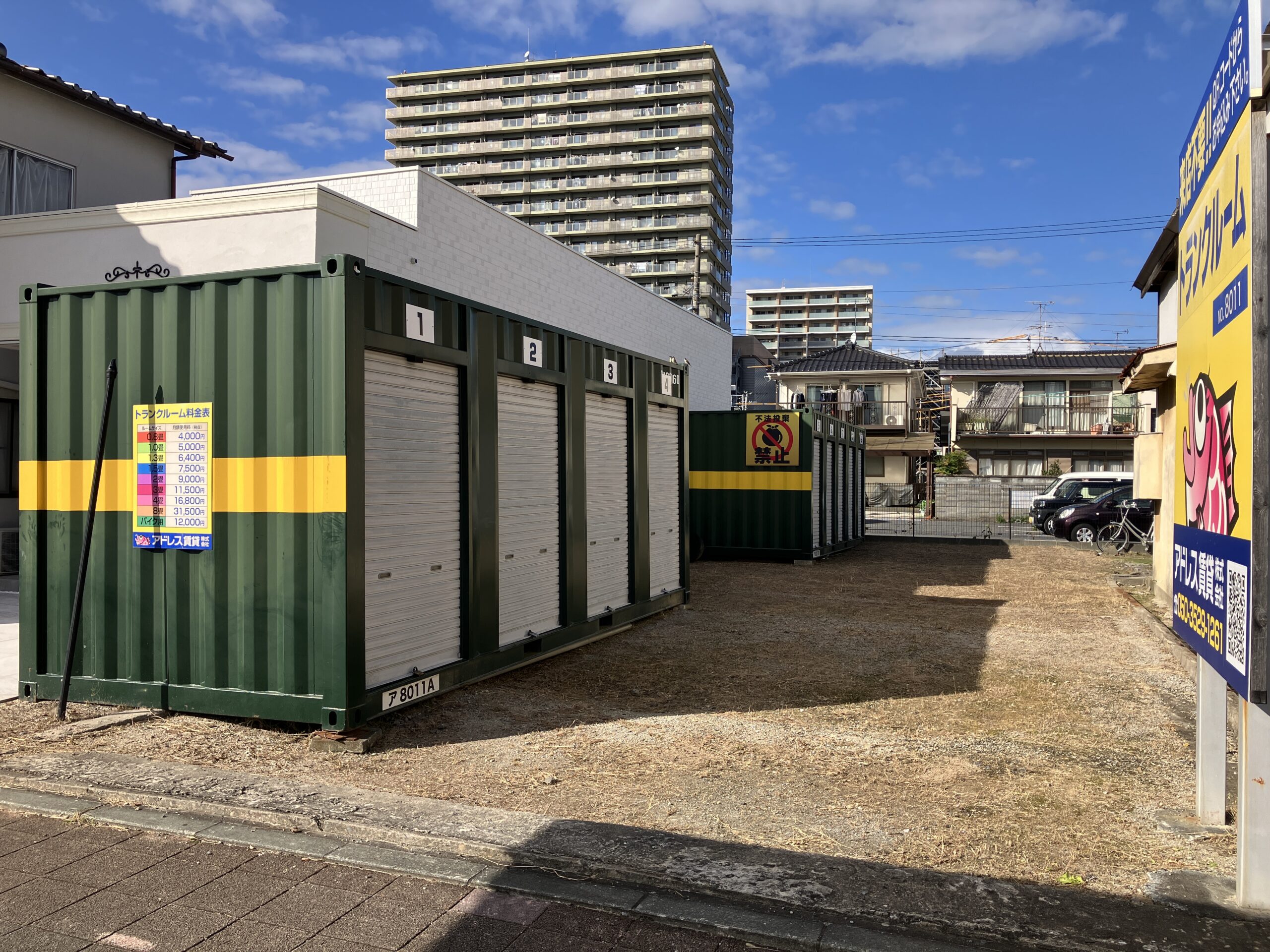 屋外に並ぶシルバーの鉄製コンテナ型トランクルームと、車を横づけして家電を運び込む男性