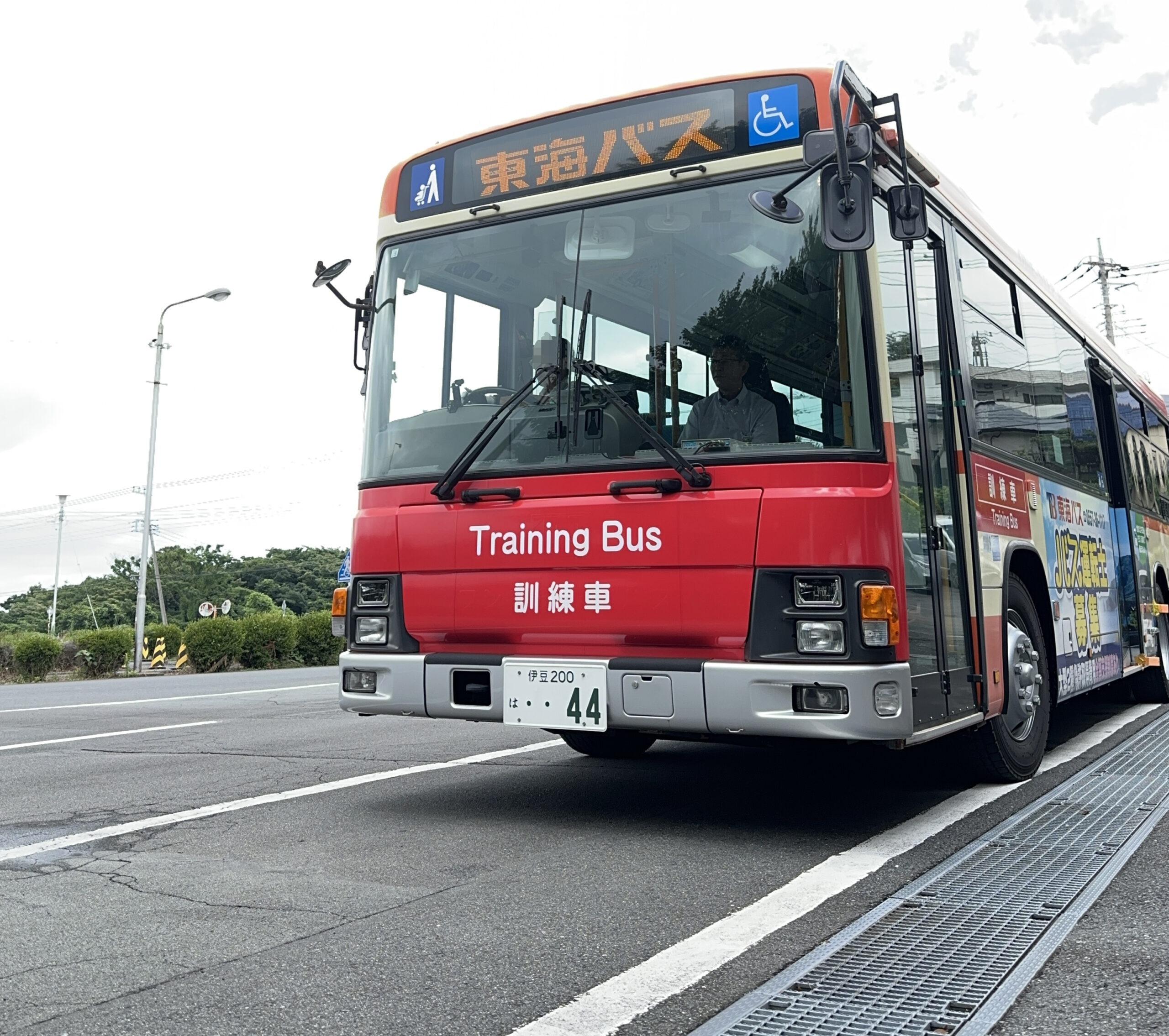 運転体験会で実際のバスの運転席に座り説明を受ける参加者