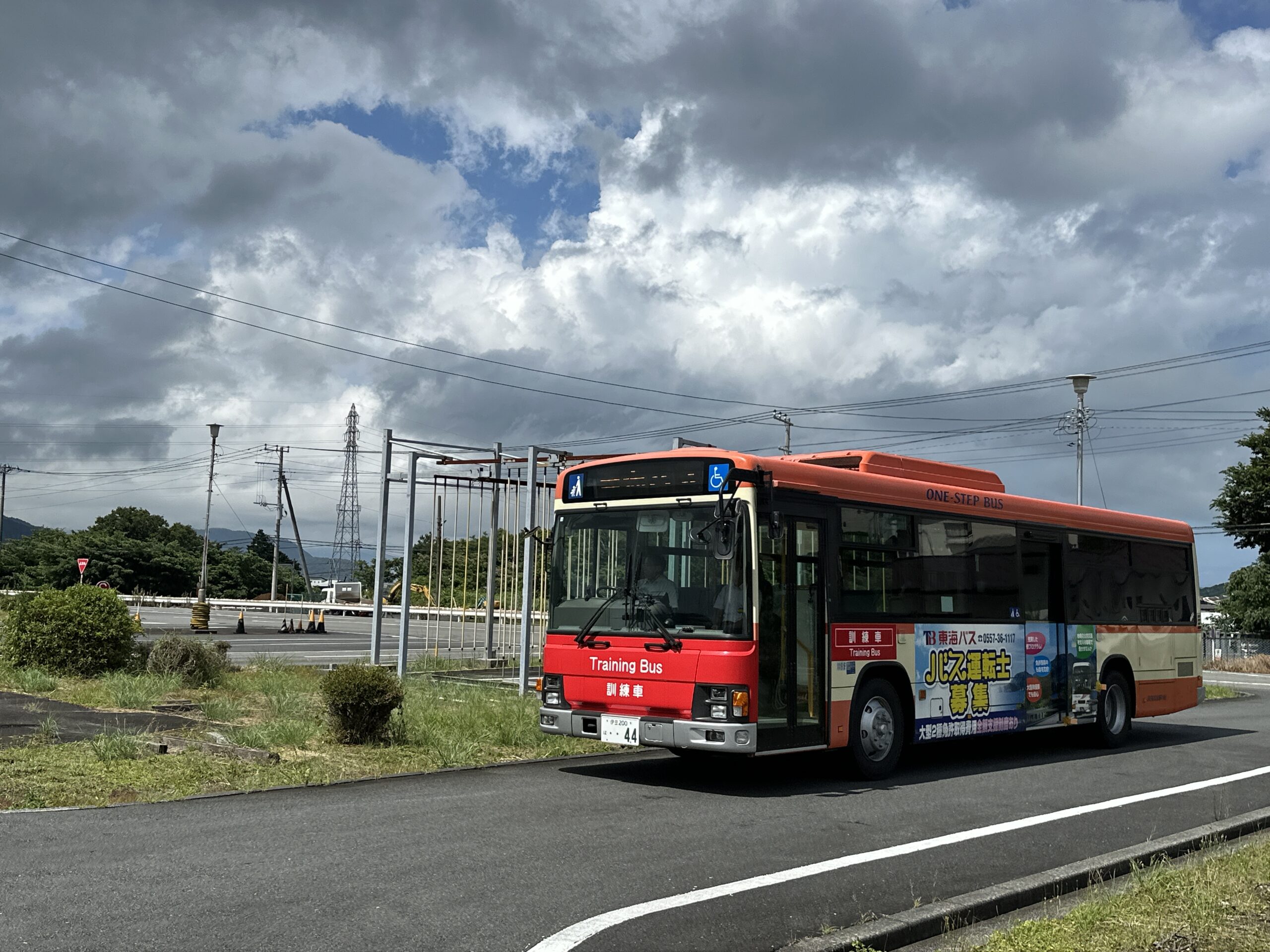 運転体験会で実際のバスの運転席に座り、インストラクターから丁寧に説明を受ける参加者