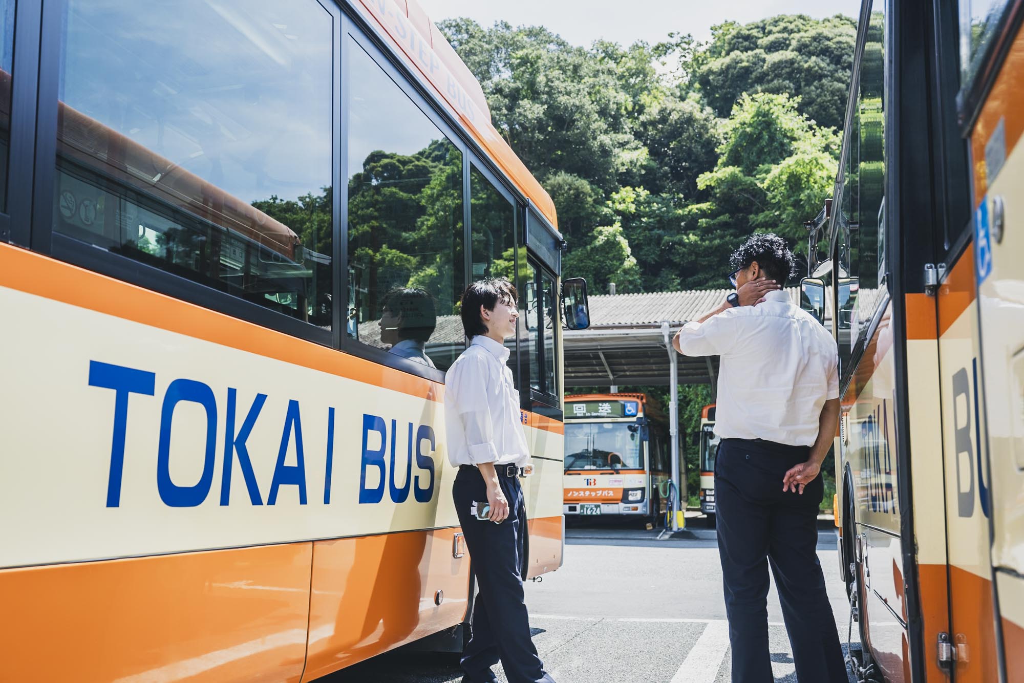 修善寺営業所の前で、同僚と談笑しながら出発準備をする東海バスの運転手たち