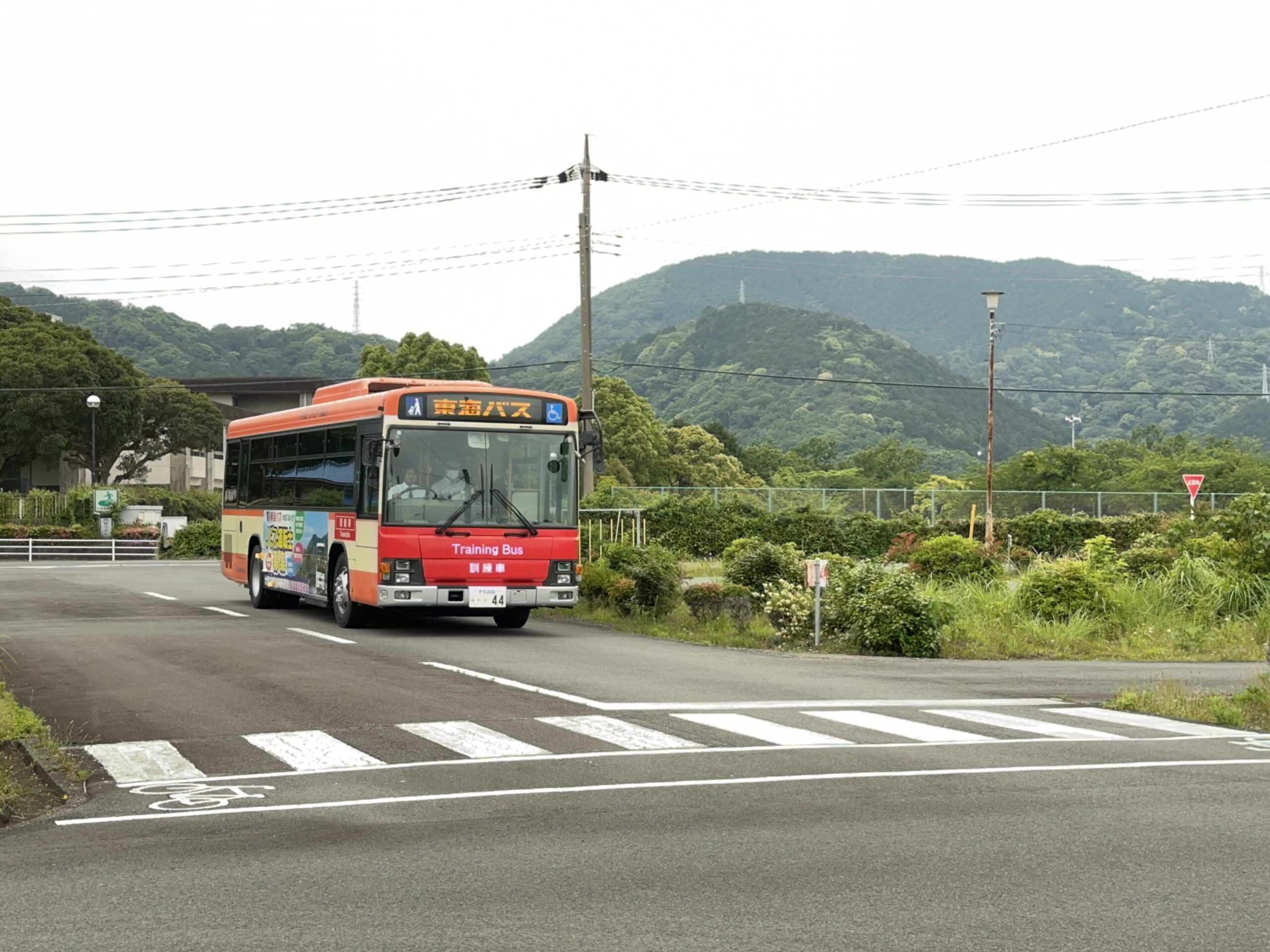 運転体験会でインストラクターから丁寧な説明を受けながら、初めてバスの運転席に座る参加者