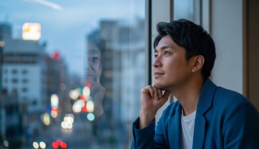 都会の窓辺で夕暮れを眺めながら地元での暮らしを思い浮かべ物思いにふける30代の男性