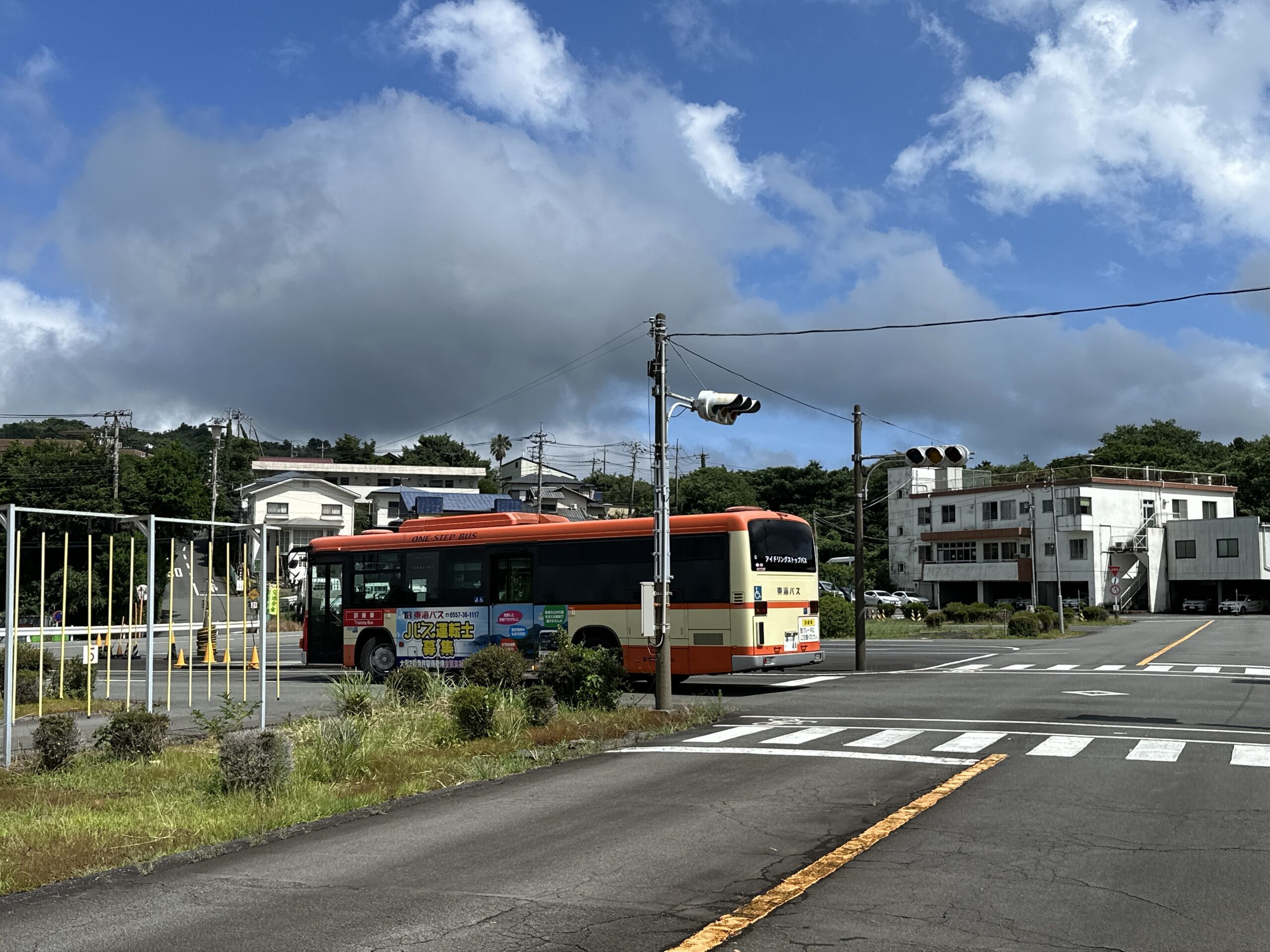 バスの運転席に初めて座り緊張と好奇心の混じった表情でハンドルを握る私服の未経験者
