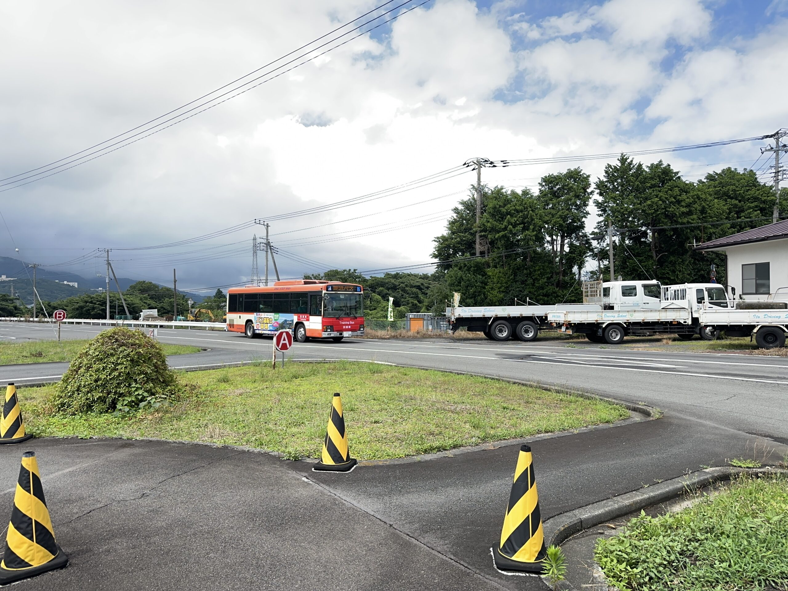 運転席から大型バスのフロントガラス越しに前方を見つめ、車体の大きさに戸惑いながらも真剣な表情を浮かべる30代の私服男性